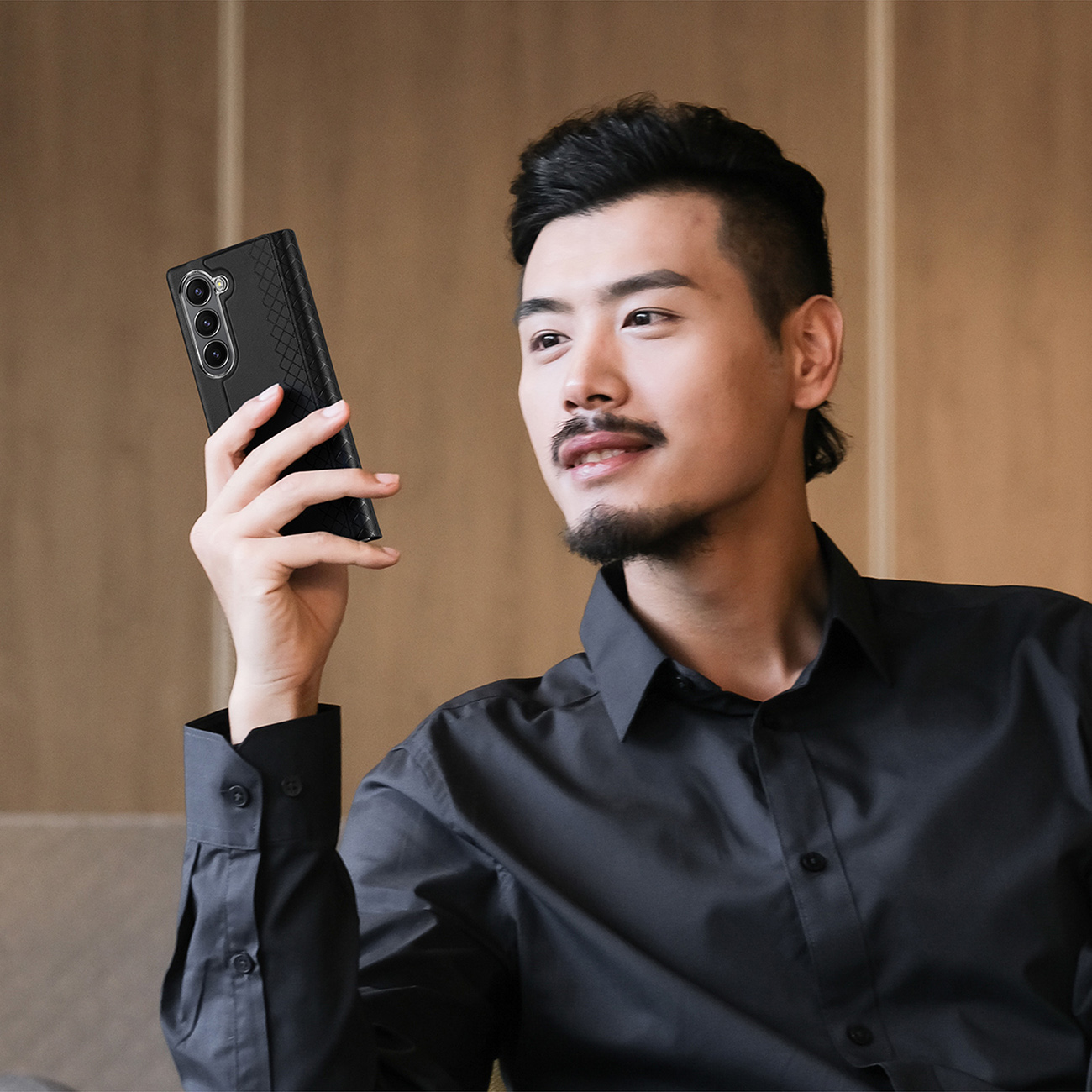 Muž používajúci telefón v koženom puzdre Dux Ducis Brill